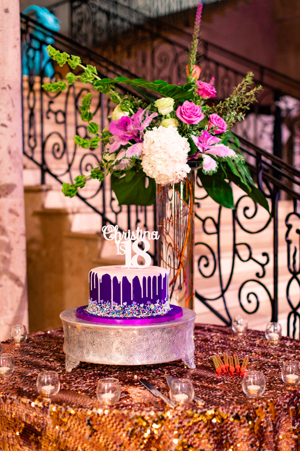 Purple and white 18th birthday cake with floral arrangement at The Bell Tower on 34th, Houston, TX.